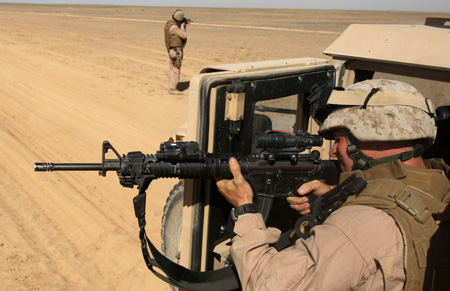 Two marines scan the area in Afghanistan during a security stop on their convoy on April 24. (AP/David Guttenfelder)