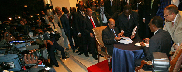 Sudan's President Omar al-Bashir, left, and Chad's President Idriss Deby, right, are surrounded by a journalists as they sign a non-aggression pact in Dakar, Senegal, Thursday, March. 13, 2008. (AP/Olivier Asselin)