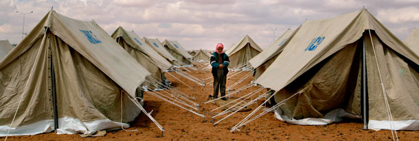 A Jordanian worker performs Muslim evening prayers during a break from setting up tents at a camp for refugees from Iraq. (AP/Lefteris Pitarakis)