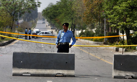 A Pakistani police officer stands guard at a road block near the site of a bomb explosion in Islamabad on March 16, 2008 blamed on Islamic militants linked to Al Qaeda. (AP/Anjum Naveed)