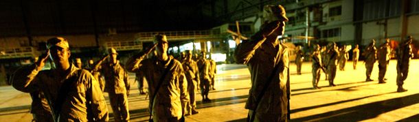 Soldiers from the 1st Armored Division salute during the playing of taps at an airport hanger during a ceremony to mark Memorial Day in Baghdad, Iraq. (AP/David Guttenfelder)