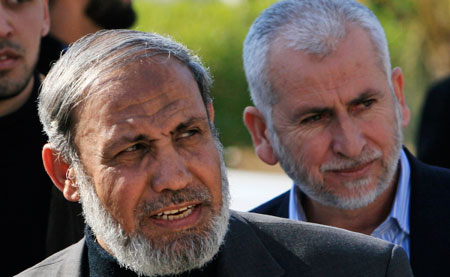 Senior Hamas leader Mahmoud Zahar, left, followed by former minister of interior Said Siam, returns from Egypt at the border at Rafah, southern Gaza Strip. (AP/Eyad Baba)