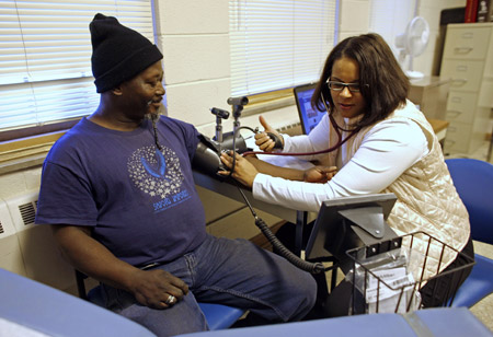 A man has his blood pressure checked by a nurse at a clinic offering treatment to the poor and uninsured. A new research report shows disparities in health care can occur along geographic as well as ethnic lines. (AP/Darren Hauck)