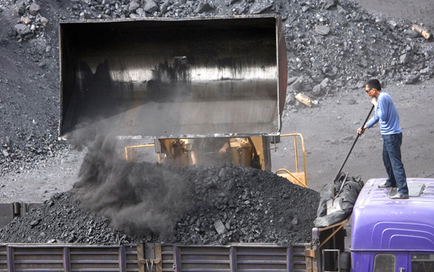 A worker watches as coal bound for power plants is shoveled onto trucks at a mine in China. The Chinese company GreenGen recently announced plans to construct a coal-fired power plant that implements carbon-capture-and-sequestration technology. (AP/Ng Han Guan)