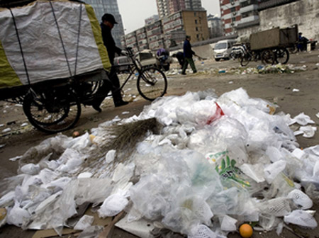 A man passes by plastic bags littered among other trash in Beijing. China has become the latest country to ban free plastic bags. (AP/Andy Wong)