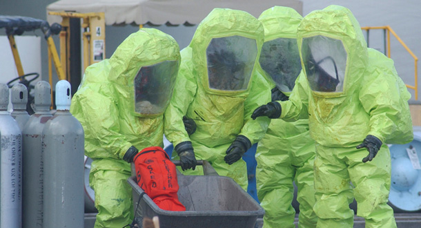 Hazardous material technicians walk to a decon area after plugging a one-ton chlorine cylinder that was leaking at Allied Universal Corporation in Miami. No one was injured and the poisonous gas was contained to the facility, but chemical plants in 23 states are located in population centers of at least 1 million people, making attractive targets for terrorists. (AP/Lt. Eric Baum)