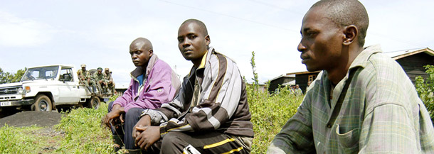 Three FDLR soldiers sit after after surrendering to the Congolese army; they are watched by Congolese soldiers on the outskirts of the city of Goma in the Democratic Republic of Congo. (AP/Riccardo Gangale)