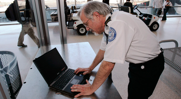 An airport screener looks at a laptop computer. The U.S. Customs and Border Patrol now has the ability to copy the contents of laptops from any travelers entering the United States. (AP/Mike Derer)