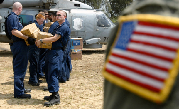 Military personnel from the USS Abraham Lincoln battle group load relief goods of food and water onto a Seahawk helicopter in Banda Aceh along the western coast of Indonesia's Sumatra island. (AP/Richard Vogel)