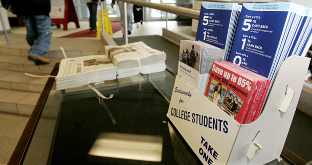 Credit card and magazine subscription pamphlets sit outside the Rutgers Newark bookstore. Students are aggressively marketed by credit card companies and often get stuck with high fees, heavy interest rates, and complex terms. (AP/Mike Derer)