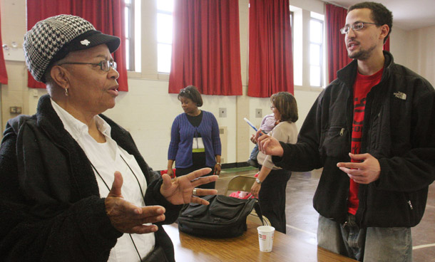 Dolores Sharrock, owner of a two-family house in danger of foreclosure in Queens, speaks to an ACORN representative at a housing crisis workshop in a Queens church gymnasium sponsored by the Roman Catholic Diocese of Brooklyn. (AP/Tina Fineberg)