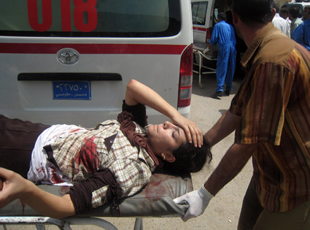 A woman injured in a bomb blast is taken to a hospital in Kirkuk, Iraq, on Monday, July 28. The explosion killed 25 people and injured another 185 at a gathering of Kurds who were protesting a provincial elections law. (AP Photo/Emad Matti)
