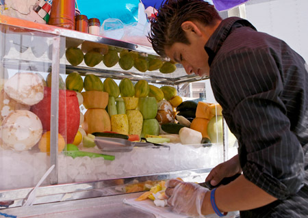 Antonio Tellez, a street vendor in Los Angeles, is one of an estimated 2 million Americans who will receive a raise today when the federal minimum wage rises $0.70, to $6.55 per hour. (AP Photo/Damien Dovarganes)