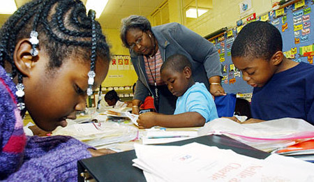 Uniontown Elementary School Principal Ora Cummings helps first grade students read at the school in Uniontown, AL, where more than one-third of students live below the poverty level. (AP/Dave Martin)