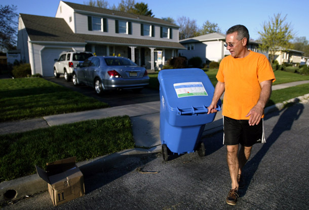 A RecycleBank participant rolls his bin out to the street for pickup in Cherry Hill, NJ. Currently operating throughout much of the northeastern United States, RecycleBank has plans to expand to new communities. (AP/Joseph Kaczmarek)
