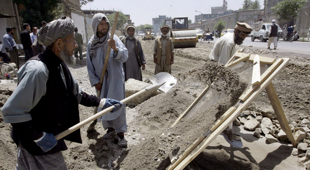 An Afghan laborer sifts sand for construction of a road as bulldozers flatten the ground in Kabul, Afghanistan on June 12, 2008. More funding for road construction should be a target area for U.S. aid. (AP/Musadeq Sadeq)
