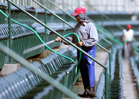 Juan Fernandez washes seats at Angel Stadium in Anaheim, CA. Unemployment rose this month to 5.7 percent, from 5.5 percent. (AP Photo/Chris Carlson)