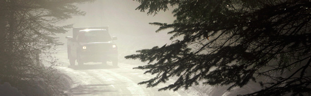 A truck in Maine makes its way through a foggy mist brought on by melting snow and warm temperatures earlier this year. The weather system that gave Maine its early thaw is also causing air quality problems; EPA had to issue a regional winter air pollution advisory for the first time in a decade. (AP/Robert F. Bukaty)