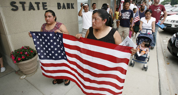 Protesters march down a street on July 27, 2008, in Postville, IA. Nearly 400 people were arrested during a May immigration raid of the local Agriprocessors plant. Federal investigators left the plant's workplace safety violations to the state attorney general. (AP/Charlie Neibergall)