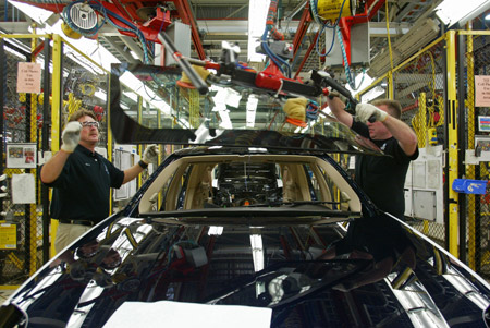 Workers install a windshield on a Cadillac at the General Motors Corp. Lansing Grand River assembly plant in Lansing, MI. Direct loans from the continuing resolution could help automakers modernize plants to produce more fuel-efficient cars. (AP/Al Goldis)