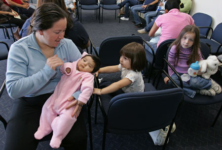 Alejandro Ruiz holds her two-month-old daughter in a hospital waiting room in Salinas, California. Two new studies have shown that improving children's health is key to improving health outcomes for adults. (AP Photo/Paul Sakuma)