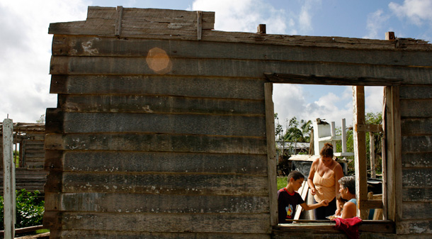 A family sits in what remains of their home that was damaged by hurricanes Ike and Gustav in Los Palacios, Cuba. Ike and Gustav caused $5 billion in damage to Cuba this month. (AP/Javier Galeano)