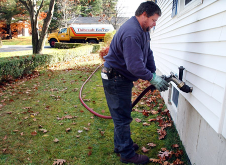 Heating oil deliveryman Charlie Thurlow fills a heating oil tank at a home in Topsham, Maine. The cost of heating homes, whether with oil, natural gas, or other means, will be more expensive this winter than last. (AP/Robert F. Bukaty)