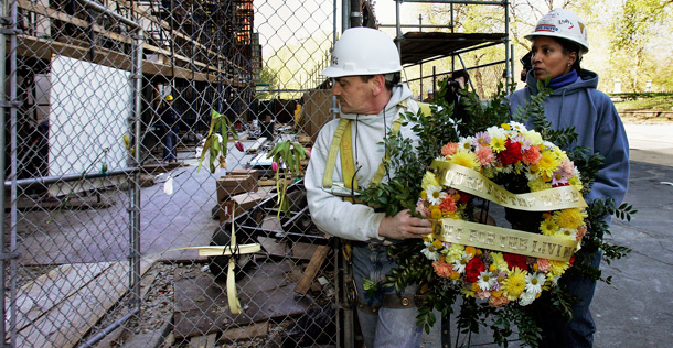 Construction workers carry a wreath to lay it at the site in downtown Boston where a scaffolding collapse killed three people. (AP/Elise Amendola)