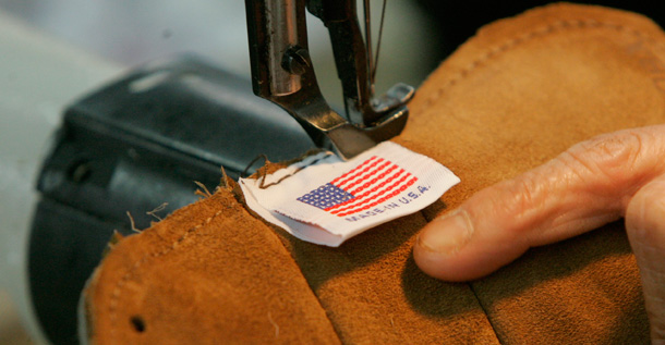 A worker sews an American flag into each glove made at the Nokona Baseball Glove Company in Nocona, Texas. American workers' productivity has increased by 20 percent since 2000, but wages have grown by less than 1 percent. (AP/Orlin Wagner)