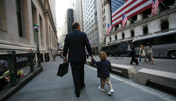A businessman walks his son to school past the New York Stock Exchange on Friday in New York. (AP/Mark Lennihan)