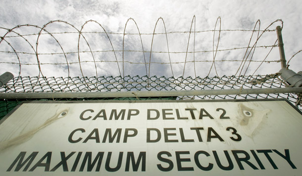 A razor-wired fence is shown above the Camp Delta 2 and 3 base sign at Guantanamo Bay Naval Base, Cuba. Closing Guantanamo should be one of five priorities for the new Obama administration to introduce a new era of U.S. human rights policy. (AP/Haraz Ghanbari)