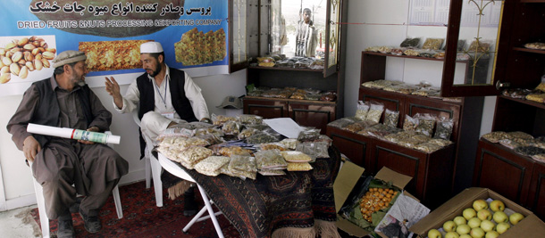 A dried food seller with a friend at a makeshift shop during the Afghanistan Agricultural Trade Fair sponsored by the United States Agency for International Development and the Afghanistan International Chamber of Commerce. The two-day fair aimed to promote the country's agriculture products and find suitable foreign markets for them. (AP/Musadeq Sadeq)