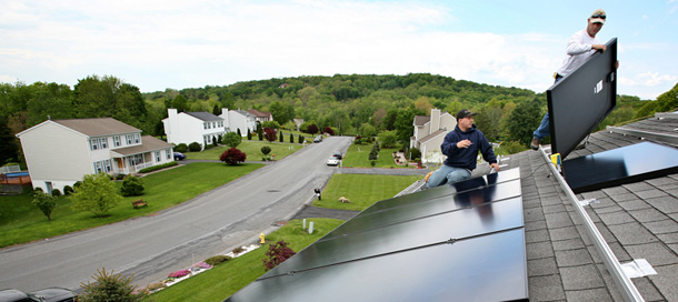 Two workers with Mercury Solar Systems install panels on the roof of a home in Newburgh, NY. (AP/Craig Ruttle)