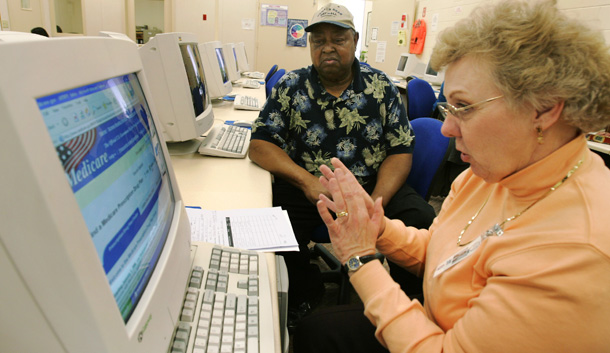 Volunteer Jane Mitchel helps Frank Johnson select a Medicare prescription drug enrollment plan at Trenholm State Technical College in Montgomery, Alabama. (AP/Rob Carr)