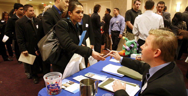 John Kasyanenko, right, of Express Employment Professionals gives his business card to a woman seeking work at a job fair sponsored by Monster.com in New York on November 12, 2008. Last month, businesses slashed 533,000 jobs, the largest monthly loss in 34 years. (AP/Kathy Willens)
