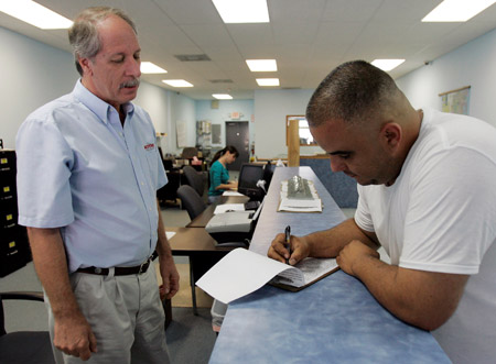 Roberto La Rosa, right, fills out a temporary job application as Frank Piccolo, branch manager of Active Staffing Services, looks on in Hialeah, Florida on November 7, 2008. Total job losses in 2008 have hit over 1.9 million, but well-designed recovery programs could restore lost jobs. (AP/Alan Diaz)