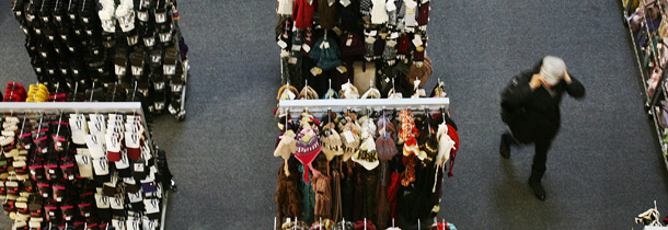 A shopper walks through the aisles of a relatively empty clothing store last week in New York. (AP/Mark Lennihan)