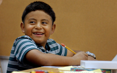 Ismael Noran works on his math homework; his family is one of the many families whose income is too low to qualify for the much-needed Child Tax Credit. (AP/David Kadlubowski)