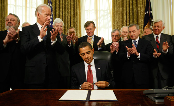 President Barack Obama caps his pen after signing an executive order closing the prison at Guantanamo Bay today in the Oval Office. (AP/Charles Dharapak)