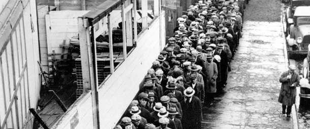 Long line of jobless and homeless men wait outside to get free dinner at New York’s municipal lodging house in 1932 during the Great Depression. (AP)