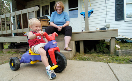 Dawn Snyder watches her son Cory play in his front yard. Cory has cerebral palsy, but his mother is unable to get government health insurance that will cover him. (AP/Mark Stahl)