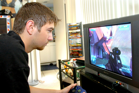 A man plays an Xbox game at his home in Jupiter, FL. Video game systems use an estimated 16 billion kilowatt-hours of electricity a year, which is roughly the annual electricity use of San Diego. (AP/Rick Silva)