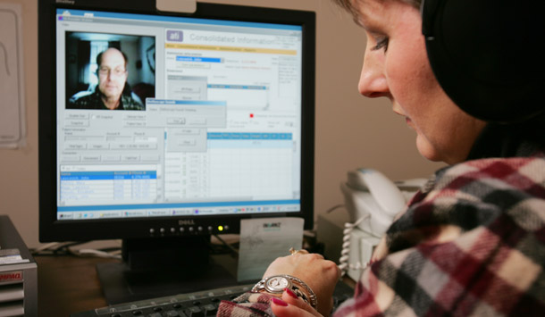Nurse Lucy Stufflebeam records a patient's heartbeat using a "home telecare" device. Video monitoring is just one form of information technology that can help promote wellness and reduce health care costs. (AP/Jim McKnight)