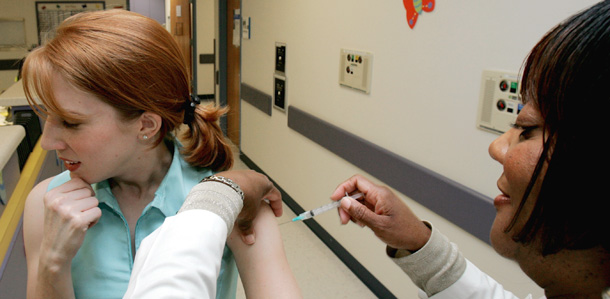 A nurse administers a vaccine. Funding eliminated from the Senate Recovery and Reinvestment Act would have provided training for and promoted jobs like this in health care. (AP/Ric Feld)