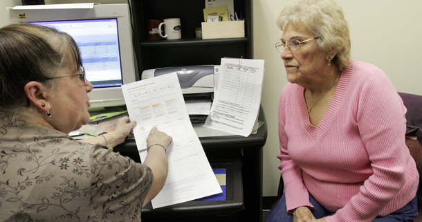 Caren-Marie Bowman, left, a volunteer counselor helps Pauline Chase, 78, sign up for her Medicare Part D prescription plan in Concord, NH. We cannot achieve health or fiscal security unless health and entitlement reform efforts address the need for affordable long-term care. (AP/Jim Cole)