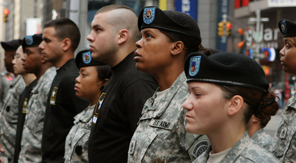 Newly enlisted army recruits, in black shirts, join recruiting officers for a ceremony in New York City. (AP/Bernadette Tuazon)