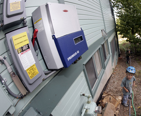 Children play near a meter used to measure the solar power being produced by the panels on a roof in a co-housing development in Lafayette, CO. Colorado was the first state to require by popular vote that utilities generate a percentage of their power from renewables. (AP/David Zalubowski)