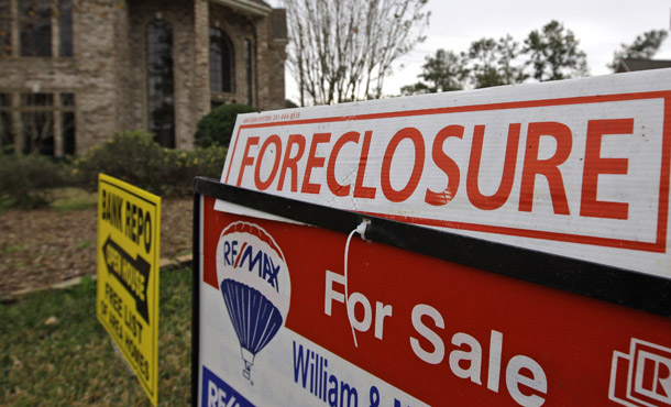 Foreclosure and for sale signs sit outside a foreclosed home in Houston, TX. The Federal Deposit Insurance Corporation and the Treasury Department need to ensure that the new Public-Private Investment Program to clean banks of toxic assets does not upend the Obama administration’s existing efforts to resolve the housing crisis. (AP/David J. Phillip)