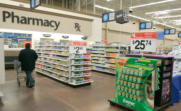 A shopper walks toward the pharmacy at a Little Rock, AK, Wal-Mart store on February 20, 2008. An increased availability of jazzy scientific-sounding press releases erodes the chance that journalists will develop original health care investigative stories. (AP/Danny Johnston)