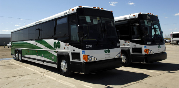New hybrid diesel-electric buses sit parked outside the Motor Coach Industries plant in Pembina, North Dakota. This project created hundreds of green jobs for engineers, plant workers, bus drivers, and others. (AP/Will Kincaid)